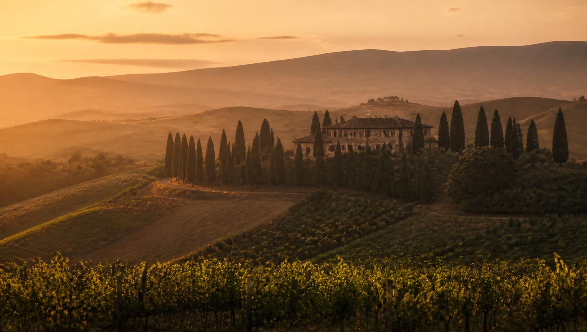 Golden light over Tuscan hills, cypress trees and a stone villa